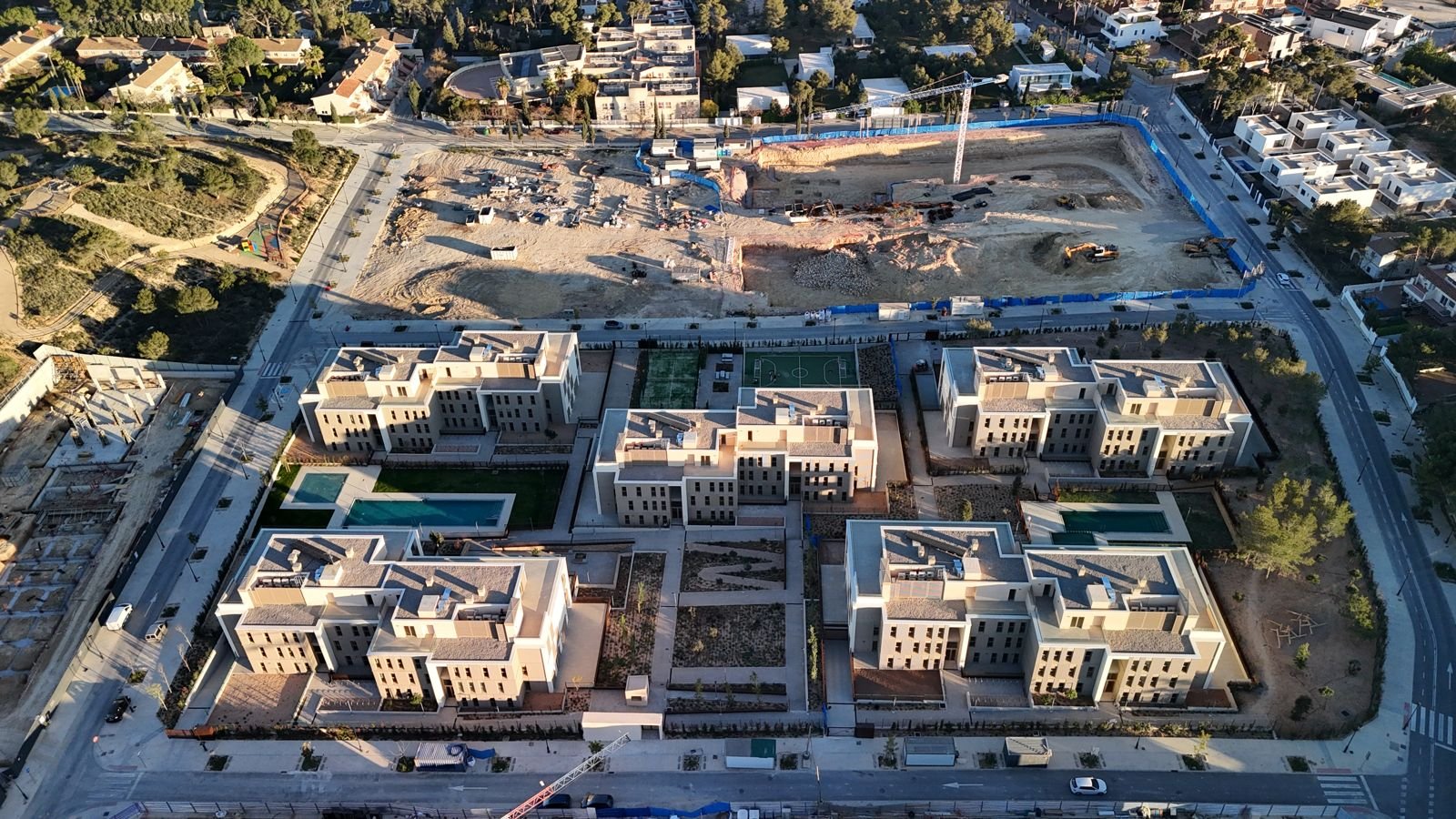 Top-down golden-hour aerial of the same development