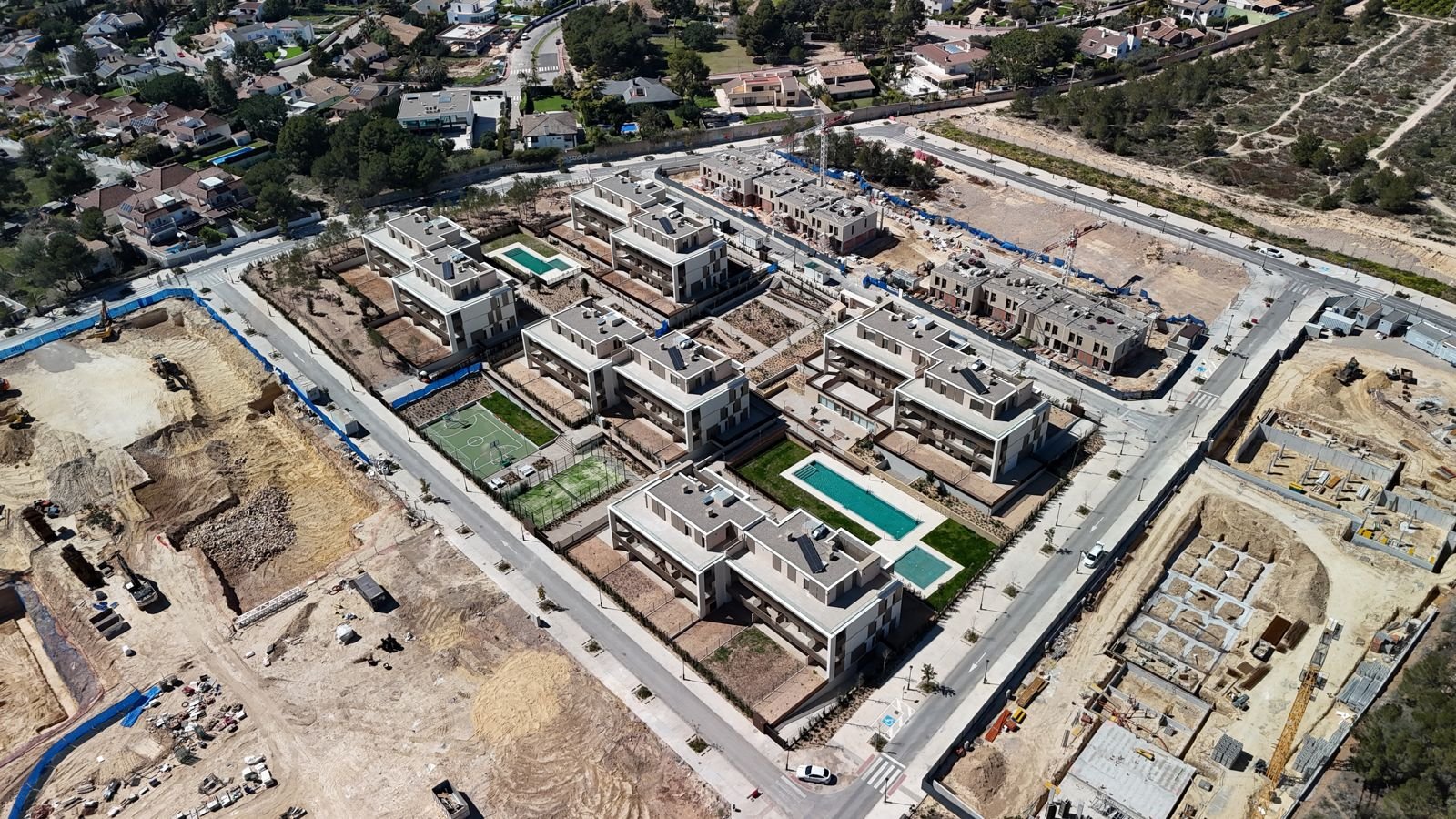 Oblique aerial of a new residential development with pools and courts